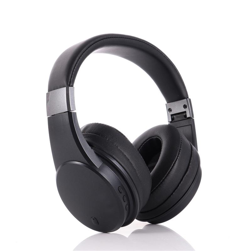 Black over-ear wireless headphones with padded ear cups and a padded headband, shown at an angle on a white background with a faint reflection below.